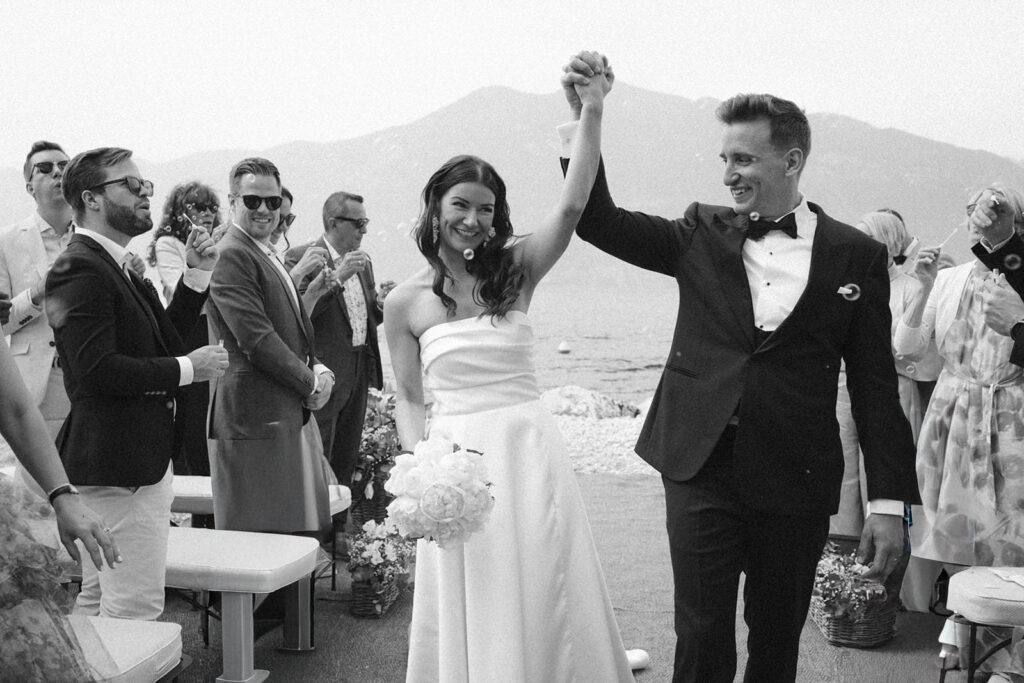 Hochzeitspaar feiert am Garda See den Auszug nach der Trauung fotografiert in schwarz weiß